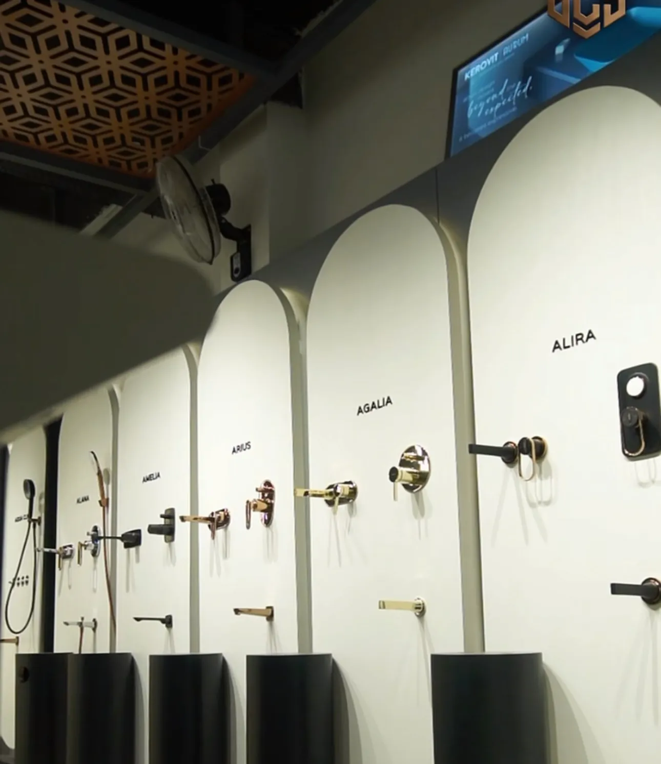 Showroom wall of arched display panels with basin mixers and black pedestal basins